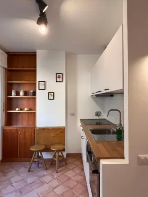 a kitchen with a sink and a counter with stools at Sampietrino Vatican Apartment in Rome