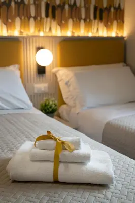 a hotel room with two beds with towels and a yellow ribbon at DoppioSei in Rome