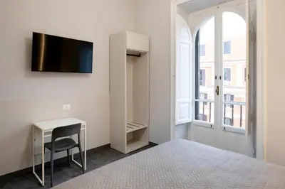 a bedroom with a bed and a desk and a tv at DoppioSei in Rome