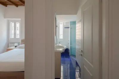 a white bathroom with a sink and a bed at Colosseum Apt in Rome