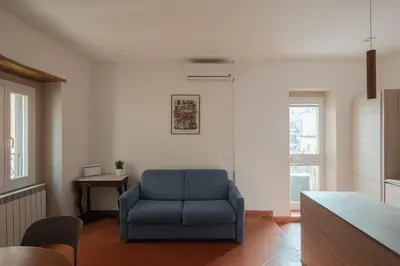 a living room with a blue chair and a table at Colosseum Apt in Rome