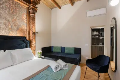 a bedroom with a bed and a couch at H77 Apartments - Maison D'Art Collection in Rome