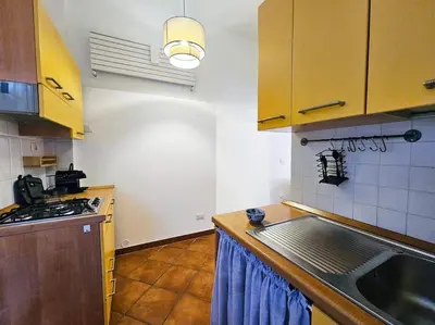 a kitchen with yellow cabinets and a sink at Vicolo di Monte del Gallo 24 - Vatican City in Rome
