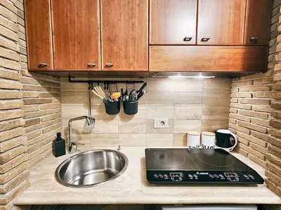 a kitchen counter with a sink and wooden cabinets at Vicolo dell'Atleta 23 - Garden in Trastevere in Rome