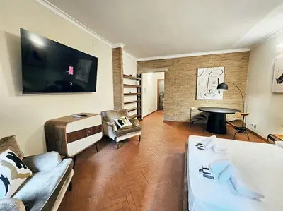 a living room with a couch and a tv at Vicolo dell'Atleta 23 - Garden in Trastevere in Rome
