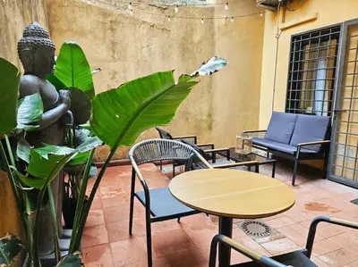 a patio with tables and chairs and a statue at Vicolo dell'Atleta 23 - Garden in Trastevere in Rome