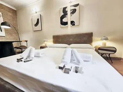 a large white bed with white towels on it at Vicolo dell'Atleta 23 - Garden in Trastevere in Rome
