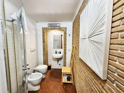 a bathroom with a toilet and a sink and a mirror at Vicolo dell'Atleta 23 - Garden in Trastevere in Rome