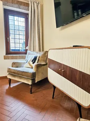a living room with a couch and a chair at Vicolo dell'Atleta 23 - Garden in Trastevere in Rome