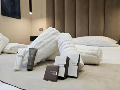 a hotel room with a bed with white sheets and shoes at Lungotevere Testaccio 11 - Amazing Flat in Rome in Rome