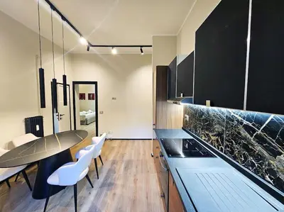 a kitchen with a table and some white chairs at Lungotevere Testaccio 11 - Amazing Flat in Rome in Rome