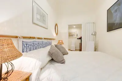 a bedroom with a white bed and a television at Central and Historic Rione near Colosseo in Rome
