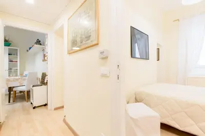a white bedroom with a bed and a dining room at Central and Historic Rione near Colosseo in Rome