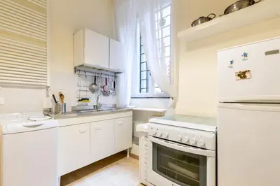 a kitchen with white cabinets and a stove top oven at Central and Historic Rione near Colosseo in Rome