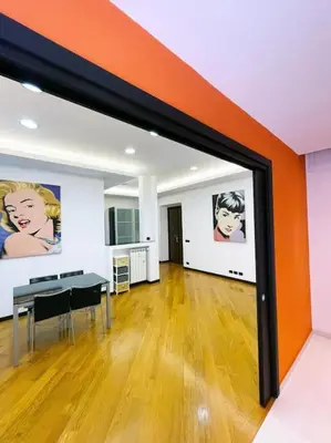 a kitchen with an orange wall and a painting on the wall at Casa Beatriz - Amazing Apartment in Rome in Rome