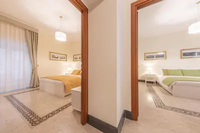 a bedroom with two beds and a mirror at St Peter's Comfort Lodge in Rome