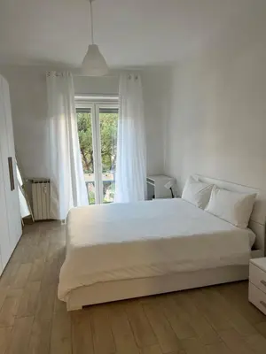 a bedroom with a large white bed and a window at Dandon Home in Rome