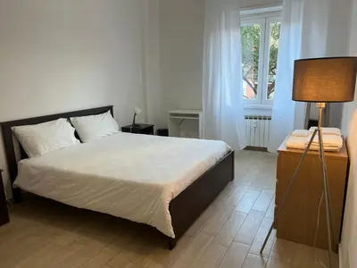a bedroom with a bed and a lamp and a window at Dandon Home in Rome