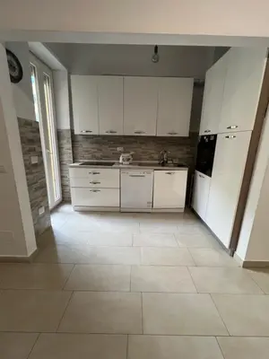 a kitchen with white cabinets and a tile floor at Dandon Home in Rome