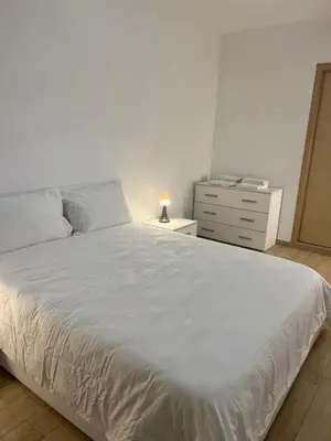 a bedroom with a white bed and a dresser at Dandon Home in Rome