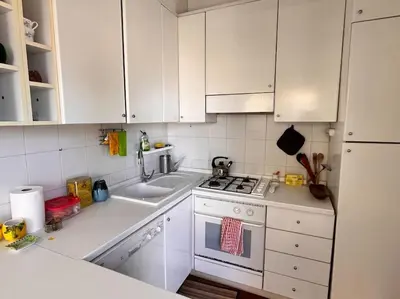 a kitchen with white cabinets and a stove and a sink at Attico luminosissimo, Città Giardino - Monte Sacro in Rome