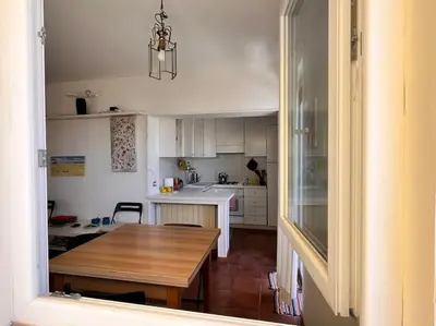 a kitchen with a wooden table and a dining room at Attico luminosissimo, Città Giardino - Monte Sacro in Rome