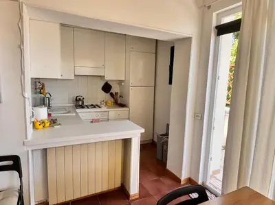 a kitchen with white cabinets and a counter top at Attico luminosissimo, Città Giardino - Monte Sacro in Rome