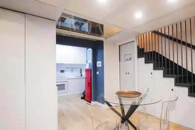 a dining room with a glass table and a staircase at Design and Colorful Loft near Villa Pamphili in Rome