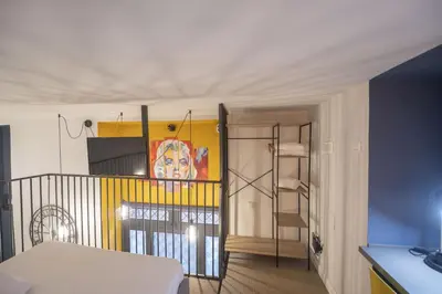 a room with a bed and a staircase with a painting at Design and Colorful Loft near Villa Pamphili in Rome