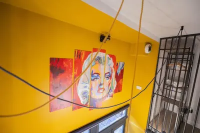 a painting on a yellow wall in a room at Design and Colorful Loft near Villa Pamphili in Rome