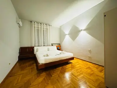 a bedroom with a bed and a wooden floor at Trastevere Tales in Rome