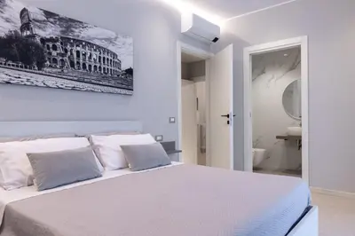 a bedroom with a white bed with a picture on the wall at Koala House in Rome