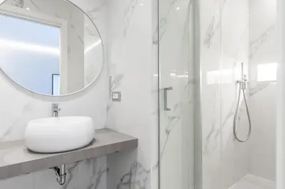 a white bathroom with a sink and a mirror at Koala House in Rome
