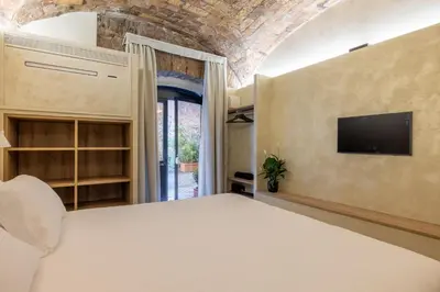 a bedroom with a bed and a tv on a wall at Trastevere Urbes Collection in Rome
