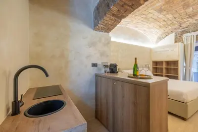 a kitchen with a sink and a bed in a room at Trastevere Urbes Collection in Rome