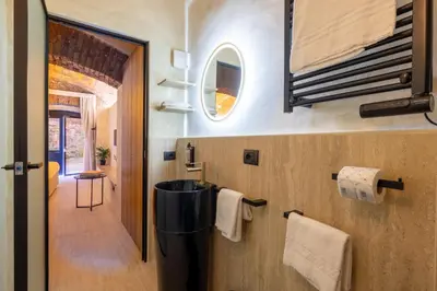 a bathroom with a mirror and towels on the wall at Trastevere Urbes Collection in Rome