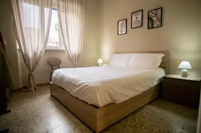 a bedroom with a bed with white sheets and a window at Vatican Comfortable 5 Bedroom Flat - 6 min METRO A by ORPI RENT in Rome