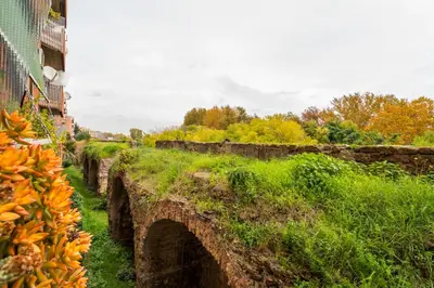 an old stone bridge in a field with trees at Art Maison Porta Portese, 10 min from Trastevere in Rome