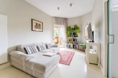 a white living room with a couch and a table at Art Maison Porta Portese, 10 min from Trastevere in Rome