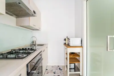 a kitchen with a stove top oven next to a refrigerator at Art Maison Porta Portese, 10 min from Trastevere in Rome