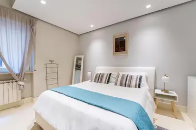 a bedroom with a large white bed and a window at Art Maison Porta Portese, 10 min from Trastevere in Rome