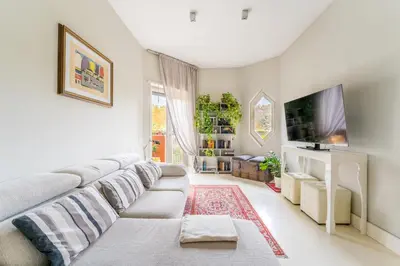 a living room with a couch and a tv at Art Maison Porta Portese, 10 min from Trastevere in Rome