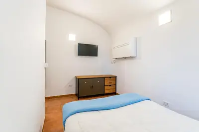a small bedroom with a bed and a tv at Archetto Loft, Cozy and Cute Place in Trastevere in Rome