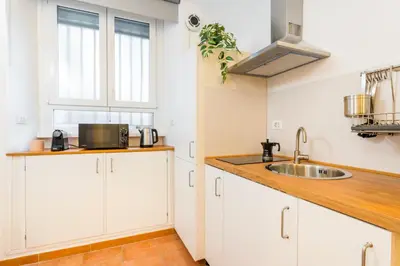 a kitchen with white cabinets and a sink at Archetto Loft, Cozy and Cute Place in Trastevere in Rome