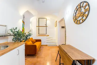 a living room with a couch and a clock on the wall at Archetto Loft, Cozy and Cute Place in Trastevere in Rome