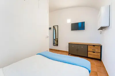 a bedroom with a bed and a dresser and a tv at Archetto Loft, Cozy and Cute Place in Trastevere in Rome