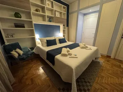a bedroom with a large bed and a chair at Room 55 Testaccio in Rome