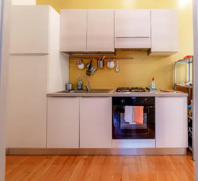 a kitchen with white cabinets and a sink at Casa Vanvitelli - Testaccio in Rome