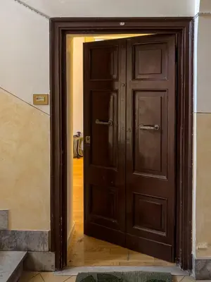 a wooden door in a room with a hallway at Casa Vanvitelli - Testaccio in Rome