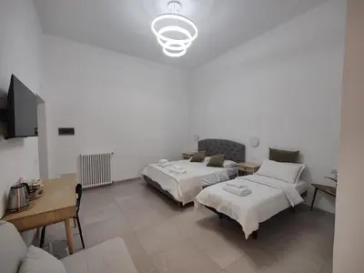 a bedroom with two beds and a table and a tv at Lifestyle 168 Guest House in Rome